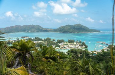 Seyşeller 'deki Hint Okyanusu' nun tekneleri, tropikal ormanları ve turkuaz sularıyla Baie Sainte Anne 'e bakan Praslin Adası' ndaki tepenin manzarası.