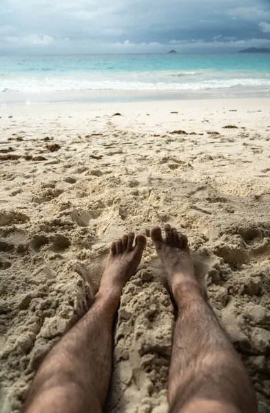 Tropikal sahildeki sıcak kumda dinlenen çıplak ayaklar yaz rahatlama, özgürlük, tatil havası, açık hava keyfi, güneşli kaçış sırasında doğal basitlik ve refahı simgeliyor.