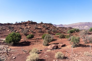 Fas yarı çölleri ve dağlar, kuzey Afrika doğası, Fas taş çölleri, kırmızı tepeler, köyler ve argan ağaçları, otobüs penceresinden Marakeş Agadir yolu manzarası