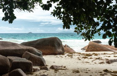 Praslin, Seyşeller 'in tropikal sahillerindeki devasa granit kayalar turkuaz deniz dalgaları ve uzak adaları seyahat, turizm ve doğa konseptleri için mükemmeldir.