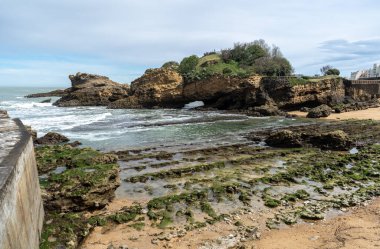 Biarritz, Fransa, 29 Mart 2024 Plage du port des pecheurs 'un yeşil taşları alçak gelgitte, editoryal görüntüde