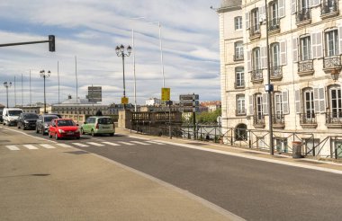 Bayonne, Fransa, 17 Nisan 2024: Bayonne 'daki köprü sahnesi trafik, klasik mimari ve Bask şehir merkezinde nehir kenarındaki sokak tabelaları ile, editoryal görüntü