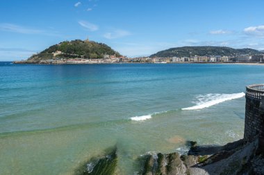 San Sebastian, İspanya, 17 Nisan 2024: San Sebastian 'daki La Concha Körfezi manzarası şehrin silueti, tepeleri ve Bask kıyısı boyunca sakin Atlantik suları, editoryal görüntü