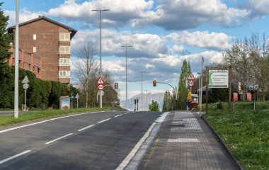San Sebastian, İspanya, 17 Nisan 2024: San Sebastian yakınlarındaki banliyö yolu, trafik işaretleri, köpek gezdiren bir kişi ve manzaralı uzak dağlar, editoryal görüntü