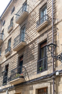 Zumaia, İspanya, 4 Nisan 2024: Zumaia 'da demir balkon ve klasik pencereli taş cephesi, geleneksel Bask kentsel mimarisini gündüz ve editoryal görüntü altında ön plana çıkarıyor