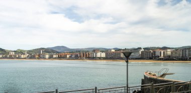 Zarautz, İspanya, 4 Nisan 2024: Zarautz kıyı kasabası, arka planda sahil, gezinti güvertesi ve dağlar. Kentsel ufuk çizgisi Atlantik kıyı şeridiyle birleşiyor, editoryal görüntü