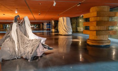 Bilbao, İspanya, 4 Nisan 2024: Bilbao Müzesi sergi alanında tekstil heykeli ve ahşap sütun. Galeri duvarı yakınındaki örtülü formlar ve yön işareti, editoryal resim