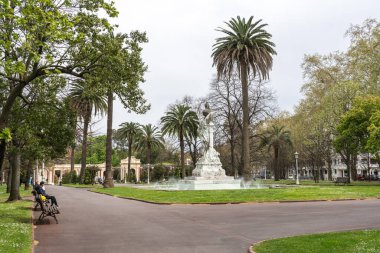 Bilbao, İspanya, 28 Mart 2024: Bilbao şehir merkezindeki palmiye ağaçları, bir çeşme ve bir mermer heykeli olan kamu parkı. Ziyaretçiler banklarda rahatlar, editoryal görüntü
