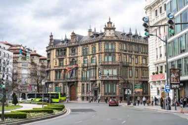 Bilbao, İspanya, 28 Mart 2024: Bilbao 'daki Moyua Meydanı' nda tarihi unsurlara sahip tarihi bina, şehir trafiği, yayalar ve otobüsler ön planda, editoryal görüntü