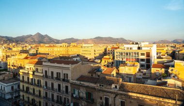 Palermo, İtalya, 18 Kasım 2024: Palermo çatıları, Monte Grifone 'un tarihi ve modern mimari ve editoryal imajın bir karışımının arkasında yükselmesiyle altın saatin altında parlıyor