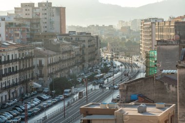 Palermo, İtalya, 18 Kasım 2024: Palermo 'da tramvay hattı boyunca sabah trafiği akıyor, tarihi binalar yumuşak gündoğumu sisi altında, editoryal görüntü