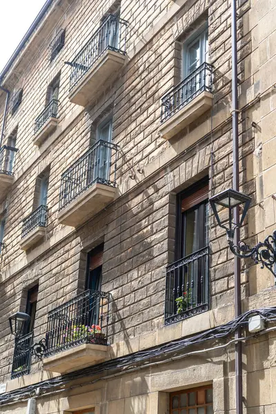 Zumaia, İspanya, 4 Nisan 2024: Zumaia 'da demir balkon ve klasik pencereli taş cephesi, geleneksel Bask kentsel mimarisini gündüz ve editoryal görüntü altında ön plana çıkarıyor