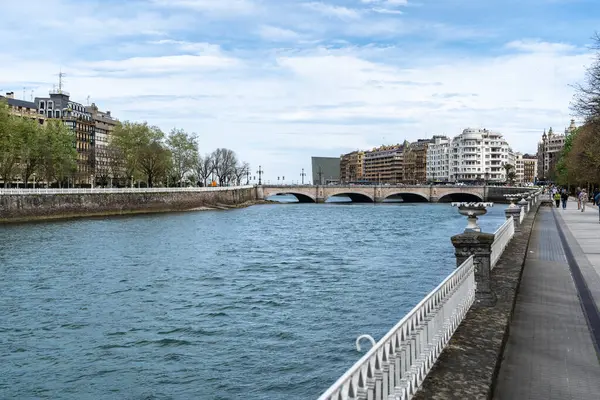 San Sebastian, İspanya, 17 Nisan 2024: San Sebastian nehri boyunca gezinti yapmak taştan bir köprüye ve Kursaal binası yakınlarındaki tarihi bir gökyüzüne götürür.