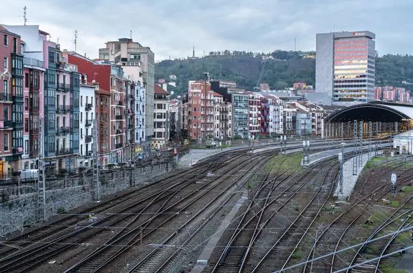 Bilbao, İspanya, 4 Nisan 2024: Bilbao Abando İstasyonu 'na giden demiryolu rayları ve arka planda yerleşim binaları ve tepeler