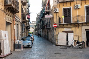 Palermo, İtalya, 18 Kasım 2024: Mobiletleri, balkonları, çamaşırhaneleri, tabelaları ve yerel dükkanları olan Dar Palermo Caddesi, otantik Akdeniz kentsel yaşamını, editoryal imajını gösteriyor