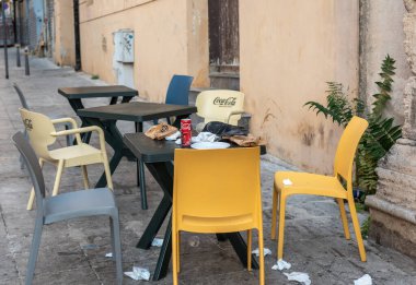 Palermo, İtalya, 18 Kasım 2024: Palermo 'da plastik sokak oturma yerleri fast food çöpleri, peçeteler ve arta kalan kırıntılar, editoryal görüntü üzerine leşen bir güvercin ile bırakıldı