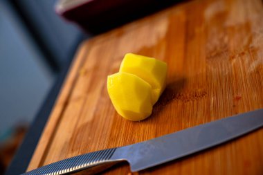 Kırsal kesim tahtasındaki tahta bıçakla patates dilimleri.