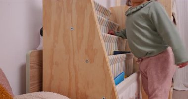 Yeni yürümeye başlayan çocuk, sıcak bir evde annesiyle birlikte okumayı öğreniyor.