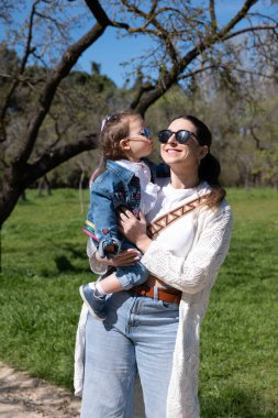 Parkta anne-kız öpüşün.