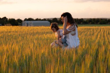 Doğadaki duygusal aile bağı, sakin bir açık hava anında altın güneş ışığıyla yıkanmış.