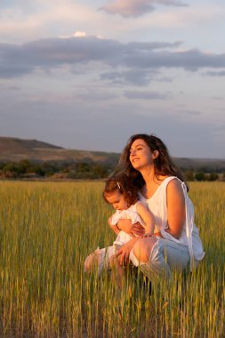Doğadaki duygusal aile bağı, sakin bir açık hava anında altın güneş ışığıyla yıkanmış.