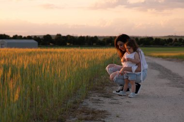 Doğadaki duygusal aile bağı, sakin bir açık hava anında altın güneş ışığıyla yıkanmış.