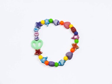 Değişik şekil ve renklerden oluşan canlı bir boncuk bilezik. Çocuk aksesuarları veya el işi projeleri için mükemmel..