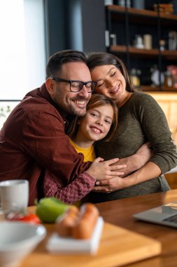 Evdeki mutfakta birbirine sarılıp kaynaşan üç kişilik genç bir aile. Anne ve baba gözleri kapalı hayal kurarken küçük kız gülümsüyor ve kameraya bakıyor..