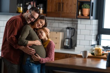 Hayalci bir aile şefkatli anlar yaşıyor, aile kucaklaşması mutfakta gözleri kapalı. Anne, baba ve kız mutfaktalar ve birbirlerine sevgiyle sarılıyorlar..