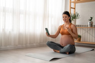 Müstakbel anne sabah egzersizine kısa bir ara verirken bir video görüşmesi yapıyor..