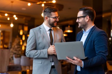 Erkek teknoloji uzmanları bir kafede tartışıyorlar. İki iş adamı şehir kafesinde dururken bir projeden bahsediyorlar..