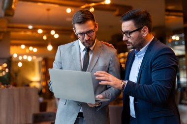 İki iş adamı online bir toplantı sırasında müşterileriyle tartışıyor. Modern iş adamları bir iş yerinde video konferansı yapıyorlar..