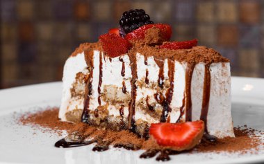 yakın plan profesyonel mutfak beyaz tabak dikdörtgen pasta üzerinde taze meyve üzerine çikolata tozu serpiştirilmiş arka plan çok fazla şeker bulanıklaştırdı