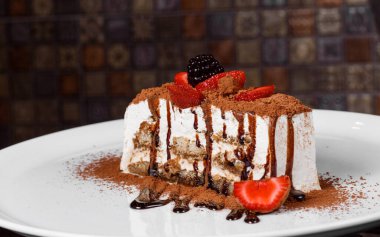 yakın plan profesyonel mutfak beyaz tabak dikdörtgen pasta üzerinde taze meyve üzerine çikolata tozu serpiştirilmiş arka plan çok fazla şeker bulanıklaştırdı