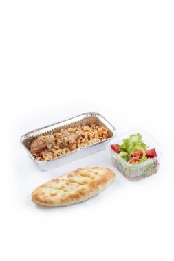 Beyaz arka planda tek kullanımlık plastik ve folyo kap krakerler uçak atıştırmalıkları havuçlu basmati pilavı, tavuk parçaları, salatalık ve domatesli ekmek doğranmış salata.