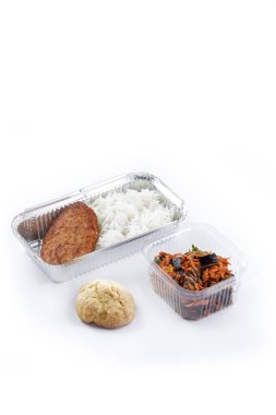 Beyaz arka planda tek kullanımlık plastik ve folyo sofra takımı yiyecek buharda pilav tavuk pirzolası sebzeli havuç salatası beyaz çörek diyet programı.