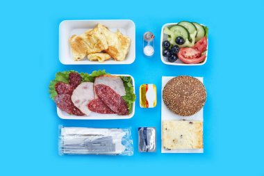 Üst düzey mavi arka plan yemekleri havayolları için tek kullanımlık sofra takımı dilimlenmiş et yağı ve krem peynirli simit süzme peynirli omlet tek kullanımlık peynir