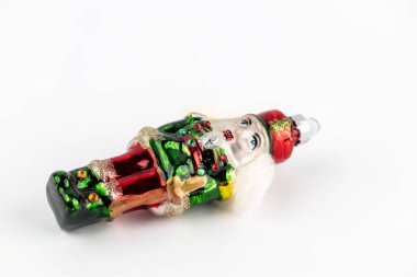 Beyaz arka planda, içine yerleştirilmiş cam kaplama Noel ağacı oyuncağı, el yapımı, süslemeli ve parıltılı teneke asker fındık kıracağı.