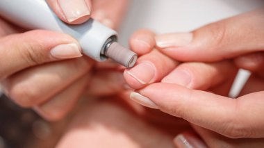 Bir güzellik salonuna yakın plan genç eller donanım manikür prosedürü friezler tırnak törpüleme iyi hazırlanmış eller vernik kaplama için popüler prosedür hazırlama