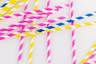 Beyaz arka planda bir çok kağıt şeritli tüpler vardır kokteyller ve farklı içecekler için pembe sarı ve mavi çizgili tüpler bahar havası