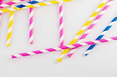 Beyaz arka planda bir çok kağıt şeritli tüpler vardır kokteyller ve farklı içecekler için pembe sarı ve mavi çizgili tüpler bahar havası