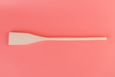 Yumuşak pembe arka planda, yeni mutfak aydınlatması, ahşap çatal bıçaklar, kaşık şekilleri, doğal ahşap kaplama spatulaları, el yapımı farklı kullanım şekilleri bulunur.