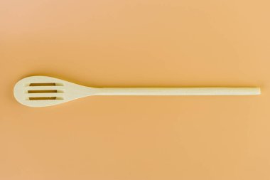 Yumuşak sarı arka planda, yeni mutfak aydınlığı, ahşap çatal şekilleri, çatallar, teflon kaplama doğal ahşap farklı kullanım türleri için spatula şekilleri bulunur.