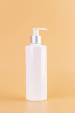 Yumuşak sarı arka plan üzerine yakın plan beyaz parlak şişe ile kozmetik güzellik endüstrisi için minimalist kap Sıvı depolama