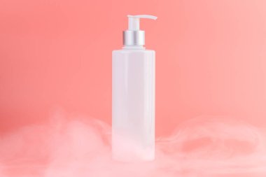 Yumuşak pembe arka plan üzerine yakın plan beyaz parlak şişe ile kozmetik güzellik endüstrisi için minimalist kap Sıvı depolama