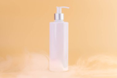 Yumuşak sarı arka plan üzerine yakın plan beyaz parlak şişe ile kozmetik güzellik endüstrisi için minimalist kap Sıvı hava deposu açık beyaz bir sis içinde duruyor
