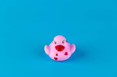 This charming and playful pink rubber duck features decorative red hearts and a classic quacking design against a vibrant blue backdrop, ideal for bath time smiles and decor. clipart