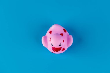Bu harika resim, kalp desenleriyle süslenmiş, neşe ve neşe uyandırmak için ideal, canlı mavi bir arkaplana sahip sevimli pembe bir plastik ördeği gözler önüne seriyor..