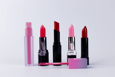 This image features an appealing assortment of lipsticks and lip gloss in beautiful shades of pink and red, ideal for enhancing your makeup routine and personal style. clipart