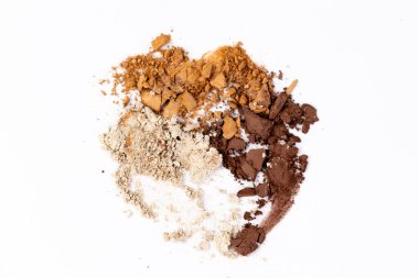 Bu resim, beyaz bir yüzeyde özenle düzenlenmiş baharat ve tatlar da dahil olmak üzere çeşitli renkli toz malzemelerini görüntüler, dokularını ve renklerini vurgular.